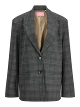 Blazer de sarga con diseño oversize, cuello con solapas y cierre frontal de dos botones. Presenta un estampado de cuadros en tonos gris oscuro y una estructura definida.