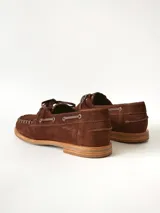 Sandalias de cuero gamuzado color marrón chocolate, diseño tipo huarache con tiras entrelazadas, tira en el empeine, talón cerrado y hebilla metálica de ajuste lateral.