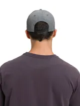 Gorro tipo baseball gris con efecto lavado, con el logo de Caterpillar bordado en amarillo en la parte frontal. Cuenta con visera curva y cierre metálico ajustable en la parte trasera.