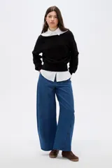 Sweater negro de viscosa con diseño holgado, cuello asimétrico y mangas largas.