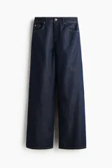 Jean de corte wide leg y tiro medio, confeccionado en denim rígido color azul oscuro con pespuntes en contraste. Presenta diseño clásico de cinco bolsillos, cierre frontal con botón y cremallera, y perneras amplias y rectas.