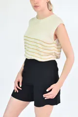 Musculosa de corte clásico y calce holgado, confeccionada en tejido de punto con diseño de rayas horizontales en tonos beige y mostaza.
