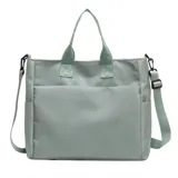 Bolso tipo tote y shopper de color negro, confeccionado en poliéster con amplio espacio interior, doble asa de mano y correa larga ajustable para llevar al hombro o cruzado.