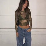 Top de microtul verde con estampado abstracto, manga larga y cuello redondo. Presenta terminaciones con dobladillo ondulado en el cuello, los puños y el ruedo.