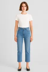 Pantalon jean de corte recto y tiro alto, con diseño clásico de cinco bolsillos y cierre frontal con botón metálico.