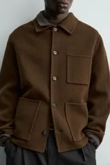 Sobrecamisa de corte regular fit confeccionada en tejido de lana doble faz color marrón. Presenta cuello solapa, manga larga, bolsillos plastrón en el delantero y cierre frontal de botonadura.