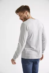 Remera de manga larga color gris melange, con cuello redondo y estampa frontal con diseño gráfico y texto.