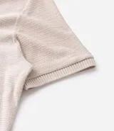 Camisa polo de corte regular, color verde oscuro, confeccionada en tejido texturizado. Presenta cuello clásico con botones frontales y mangas cortas.