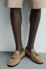 Mocasín de vestir para hombre, confeccionado en piel con acabado serraje de color tostado, con detalle de borlas en el empeine y suela de ligero tacón.