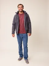 Campera de nylon gris con capucha, cierre frontal completo y bolsillos laterales. Presenta un diseño minimalista con logo bordado en el pecho.