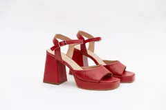 Sandalias de cuero negro con plataforma, taco ancho de 9 cm y tira ajustable al tobillo con hebilla metálica dorada.