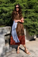 Vestido midi de corte recto, color marrón en la parte superior y marrón rojizo en el inferior con detalle de franjas horizontales superpuestas. Cuenta con escote en V y mangas cortas holgadas.