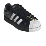 Championes adidas Superstar de plataforma, color negro con las icónicas tres tiras laterales en blanco y puntera de goma blanca. Presentan un diseño clásico con cordones negros y detalle metálico en la parte superior.