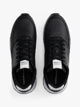 Zapatillas deportivas Tommy Hilfiger de estilo running, confeccionadas en una mezcla de piel y poliuretano. Presentan un diseño de corte bajo con cordones, paneles de texturas mixtas, detalles de ventilación en la parte superior y suela de goma con tacos.
