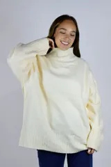 Buzo de punto color blanco marfil, con cuello alto, mangas largas y diseño holgado con puños y dobladillo acanalados.