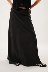 Falda larga negra confeccionada en tela suave con acabado tipo piel de durazno y cierre invisible lateral.