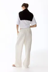 Pantalón de corte holgado en tejido liviano de mezcla de lino. Modelo de tiro alto con cintura elástica y cordón para ajustar fino, bolsillos laterales discretos y piernas rectas.