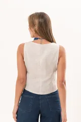Chaleco beige de lino con escote en V, sin mangas y cierre frontal con botones nacarados.