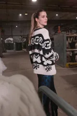 Cardigan tejido de lana color crudo y negro con cierre frontal.