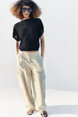 Top de punto pointelle color negro, con cuello redondo y mangas cortas anchas de diseño holgado.