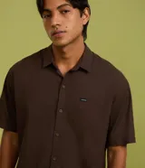 Camisa de corte relajado para hombre, confeccionada en una mezcla de cáñamo y algodón. Presenta cuello inglés, mangas cortas, cierre frontal con botones y un bolsillo de parche en el pecho con una pequeña etiqueta de la marca Ripping.
