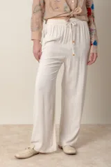 Pantalón ancho color beige de lino y rayón, con cintura elastizada y cordón ajustable.