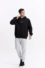 Canguro de felpa color crema, con capucha y bolsillo canguro frontal. Presenta un pequeño estampado con el logo de la marca en el pecho.