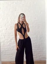 Body negro con escote halter cruzado y abertura en el abdomen.