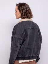 Campera de jean con interior de corderito, cuello clásico, cierre frontal con botones metálicos, bolsillos frontales y laterales, y elástico en la cintura.