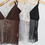 Top de malla transparente con tirantes finos, escote en V y bordado de lentejuelas y abalorios con diseño floral.