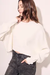 Sweater color crema de tejido de punto, corte crop y mangas abullonadas.