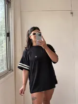 Remerón negro de algodón con mangas cortas y detalle de dos tiras horizontales blancas en las mangas.