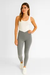 Calza deportiva de tiro alto con diseño en V en la cintura, confeccionada en tejido elástico color gris.