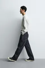 Jeans de hombre relaxed straight fit, color azul oscuro, confeccionados en denim rígido sin prelavados. Presentan cinco bolsillos, bolsillos plastrón y tira multifunción en las perneras. Cierre frontal con cremallera y botón.