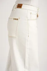 Jean baggy tiro alto color blanco con costuras en contraste color tostado, de diseño abovedado en las piernas.