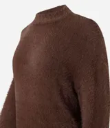 Suéter de punto color crema con cuello redondo y mangas largas ajustadas. Modelo slim alargado con efecto de pelitos.