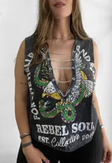 Musculosa gris con estampa de un águila y texto "Rebel Soul". Tiene cuello en V con ojales y cadenas metálicas.