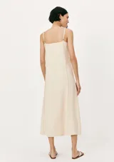 Vestido midi de corte recto y escote cuadrado, con tirantes finos y costuras verticales decorativas a lo largo de la prenda. Color bordó.