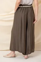 Pantalón italiano ancho color crudo, con cintura elastizada, cinto trenzado y bolsillos laterales.