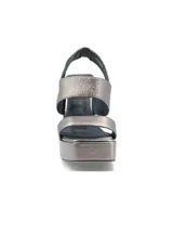 Sandalias de plataforma con taco cuadrado alto, confeccionadas en cuero metalizado color dorado. Presentan un diseño de tiras anchas cruzadas en el empeine y cierre con pulsera al tobillo.