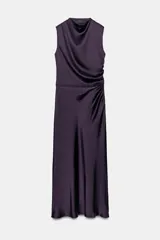 Vestido largo color morado de tejido satinado, sin mangas, con cuello fluido y detalle de drapeado en el lateral.