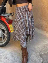 Pollera midi de corte asimétrico con diseño irregular y estampado cuadrillé en tonos marrón y celeste. Presenta cintura alta y silueta fluida con caída liviana.