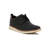 Zapato acordonado de vestir color negro, con detalles en marrón en el talón y suela de goma color crema.