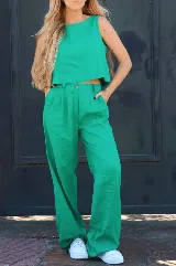 Pantalón verde esmeralda de lino, con pinzas frontales, bolsillos y cintura elástica.