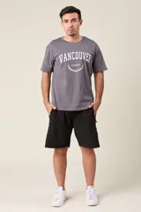 Bermuda deportiva color verde militar, de corte suelto, con cintura elástica y cordón de ajuste. Cuenta con detalles de líneas verticales en los costados y bolsillos laterales con cierre.