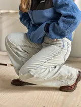 Jean wide leg de tiro alto y pierna ancha, confeccionado en denim de color celeste claro con acabado desgastado. Cuenta con diseño clásico de cinco bolsillos y cierre frontal con botón y cremallera.