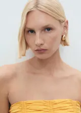 Top bandeau amarillo con diseño fruncido en el cuerpo, sin mangas y cierre de cremallera en la espalda.