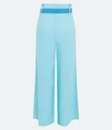 Pantalón acampanado de lino color celeste, con bolsillos, cinturón bordado y pliegues delanteros.