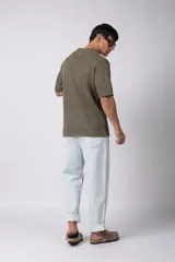 Camisa de punto calado en color beige, de manga corta y corte relajado. Presenta cuello tipo bowling, cierre frontal con botones al tono y una estructura liviana y respirable confeccionada en algodón.