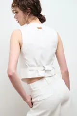 Chaleco sastre color amarillo mostaza, confeccionado en lino con forro de algodón y cierre frontal con botones.